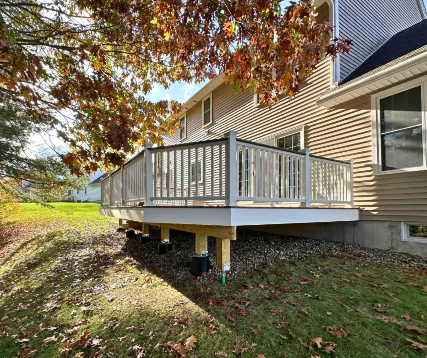 Deck Attached to the Side of a House with Grass and Tree